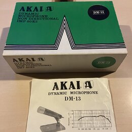 Zelená krabice a doprovodný manuál k dynamickému mikrofonu. Na obou předmětech je uveden název značky AKAI a model DM-13, dále nápisy DYNAMIC MICROPH…