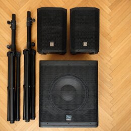 Dva černé reproduktory s logem Ey a jeden větší černý subwoofer s logem KALI. Soubor doplňují dva černé rozkládací reproduktorové stojany. Všechny ko…