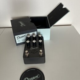 Šedý efekt pedál s nápisem Dream '65 REVERB-AMP. Na horní části jsou čtyři černé ovládací knoflíky s popisky DRIVE, TONE, VOLUME a REVERB, v dolní čá…
