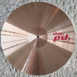 Kruhový činel v bronzové barvě s viditelným broušením povrchu. Na pravé straně je červený nápis pAiste PST 7 a pod ním menší text 20" LIGHT RIDE. Pov…
