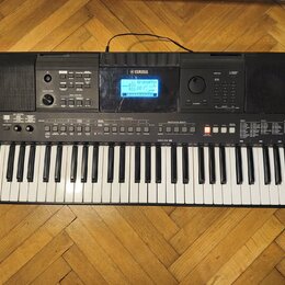 Černý digitální klavír s bílými a černými klávesami. Na horní části je logo YAMAHA, displej s nápisem BrandPro a vpravo označení modelu PSR-E463. Nás…