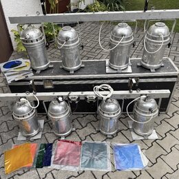 Čtyři stříbrné kovové reflektory jsou umístěny na horní liště a další čtyři na spodní liště černého transportního kufru. Všechny reflektory mají cyli…