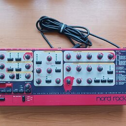 Červený virtuální analogový syntetizátor s nápisem nord rack 2 virtual analog. Na předním panelu jsou umístěny početné ovládací knofíky, tlačítka a n…