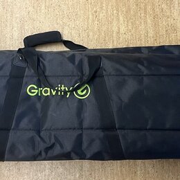 Černý textilní obal na hudební nástroj s limeňkově zeleným svislým pruhem v levé části. Uprostřed je umístěno limeňkově zelené logo s nápisem Gravity…