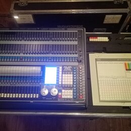 Světelný kontrolér v transportním kufru. Na zařízení je nápis LIGHT CONTROLLER a logo Avolites s označením TITAN. Ovládací panel obsahuje velké množs…