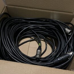 V kartonové krabici je smotaný černý kabel s konektory XLR. Na povrchu kabelu je nápis LOW NOISE CABLE a na jednom z konektorů je viditelné logo NEUT…