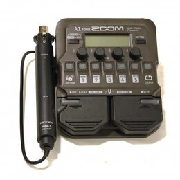 Šedý multifunkční procesor s nápisem A1 FOUR ZOOM Multi-Effects Processor. Zařízení obsahuje displej, ovládací knoflíky a pět stoupacích spínačů s čí…