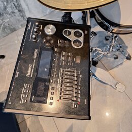Černý elektronický bicí modul Roland TD-20. Na zařízení je vidět nápis Roland a modelové označení V-Drums SOUND MODULE TD-20. Modul obsahuje několik…