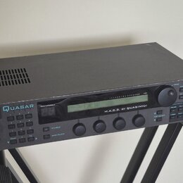 Černý elektronický hudební modul s nápisy QUASAR a M.A.S.S. BY QUASIMIDI. Zařízení obsahuje LCD displej, několik ovládacích tlačítek, pět otočných po…