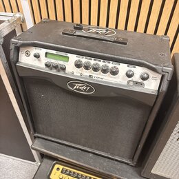 Černý kytarový kombo zesilovač s logem Peavey na horní části a na mluvící sítce. Na ovládacím panelu je nápis VYPYR a označení VLA-3. Pod ovládacími…