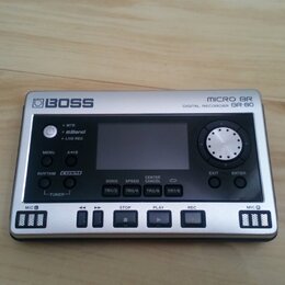 Stříbrný digitální rekordér s nápisy BOSS a MICRO BR DIGITAL RECORDER BR-80. Zařízení má černé ovládací prvky, displej a tlačítka s označením MENU, A…
