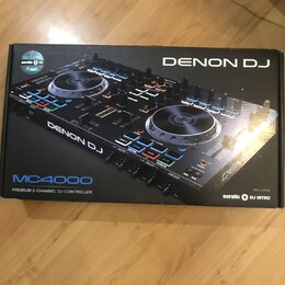 Kartonová krabice s obrázkem černého DJ kontroléru. Na krabici jsou nápisy DENON DJ, MC4000 a PREMIUM 2-CHANNEL DJ CONTROLLER. V pravém dolním rohu j…