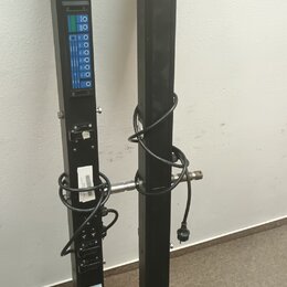 Dvě černé, úzké a vysoké lineární reproduktorové sloupy z kovového materiálu. Levý sloup obsahuje panel s modrými prvky, několika konektory a přepína…