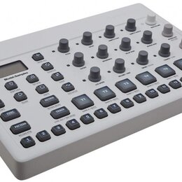Světle šedý sampler s digitálním displejem a řadou ovládacích tlačítek a potenciometrů. Na panelu je nápis Model:Samples. Zařízení vykazuje čistý pov…