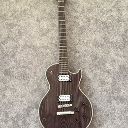 Elektrická kytara s tmavě fialovým povrchem s výraznou strukturou dřeva a bílým lemováním. Na hlavě je nápis "LTD". Nástroj má dva humbuckery s bílým…