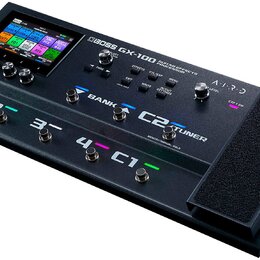 Černý kytarový procesor s displejem a expresním pedálem. Na horní části je nápis BOSS GX-100 GUITAR EFFECTS PROCESSOR a logo AIRD. Zařízení obsahuje…