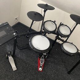 Elektronická bicí souprava značky Roland řady V-Drums v černé barvě. Na modulech a pady jsou viditelné nápisy Roland a V-Drums. Souprava obsahuje pět…