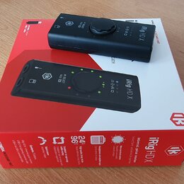 Černý digitální audio rozhraní iRig HD X položený na své originální červeno-bílé krabici. Na zařízení i na obalu je vidět logo IK Multimedia a nápis…