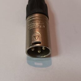 Konektor typu XLR s kovovým stříbrným tělem a černým plastovým krytem kabelu. Na boku je vyražen nápis NEUTRIK a logo v oválu. Povrch kovu vykazuje l…