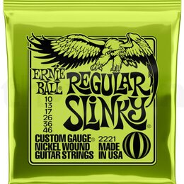 Zelené plastové balení kytarových strun s černým potiskem. Na obalu je nápis ERNIE BALL, REGULAR SLINKY a seznam průměrů strun 10, 13, 17, 26, 36, 46…