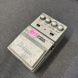 Stříbrný efekt pedál s nápisem Ibanez na spodním krytu. Na horním panelu jsou čtyři ovládací knoflíky a přepínače s popisky SPEED, DEPTH, DELAY TIME,…
