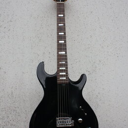 Černá elektrická kytara s dvojcutem a hnedým hmatníkem. Na hlavě je bílý nápis "LTD" a pod ním menší text "Series". Nástroj má dva humbuckery, tři ov…