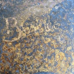Detailní pohled na povrch kovového činele s výraznou Oxidací a hnědožlutými skvrnami koroze. Na povrchu je vyražen nápis MADE IN TURKEY a modelové oz…