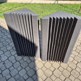 Dvě šedé akustické pěnové panely s žebrovaným povrchem. Panely mají tvar kvádru s vertikálními drážkami a jsou umístěny vedle sebe na dlažbě. Na povr…
