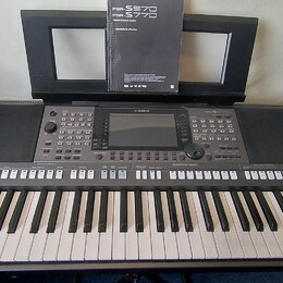 Tmavě šedý digitální klavír značky YAMAHA. Na ovládacím panelu jsou tlačítka,točítka a displej; nad klávesami je nápis STYLE CONTROL. V hudebním stoj…