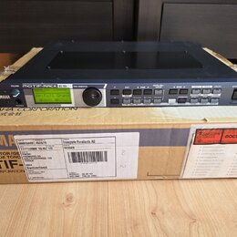 Černý rackový zvukový modul Yamaha Motif-Rack ES umístěný na originální kartónové krabici s nápisy YAMAHA CORPORATION a MOTIF. Na předním panelu je d…