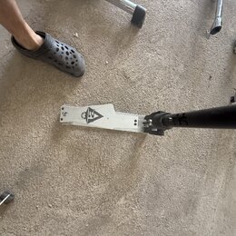 Kovový pedál basového bubnu stříbrné barvy s černým logem znázorňujícím stylizované písmeno A a lebku. Na levém okrave je malý nápis "Rd". Povrch ped…