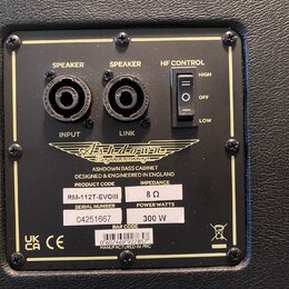 Záběr na zadní panel basové reproducingové skříně s černým povrchem. Panel obsahuje dva konektory typu Speaker (INPUT a LINK) a přepínač HF CONTROL s…
