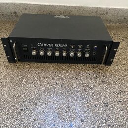 Černý basový zesilovač v rackovém provedení s nápisem CARVIN B1500 BASS AMPLIFIER. Přední panel obsahuje několik ovládacích knoflíků, přepínačů a vst…
