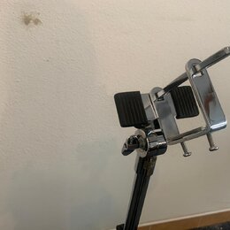 Chromovaná kovová držák na noty s dvěma černými gumovými plochami. Na utahovacím šroubu je viditelný nápis LOCK. Povrch je lesklý, s mírnými odlesky…