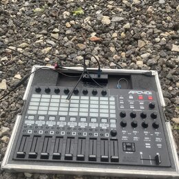 Černý MIDI kontrolér APC40 mkII značky AKAI PROFESSIONAL v hliníkovém transportním kufru s černým polstrováním. Zařízení obsahuje mřížku podsvícených…