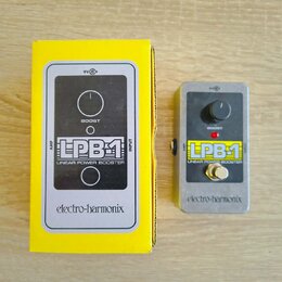 Žlutá krabice a efekt pedál značky electro-harmonix. Na zařízení i na obalu je nápis LPB-1 LINEAR POWER BOOSTER a označení vstupů AMP a INPUT. Pedál…