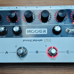 Stříbrno-černý kytarový předzesilovač s nápisy MOOER a PREAMP LIVE. Horní černý panel obsahuje šest otočných ovladačů s červenými indikátory a popisk…