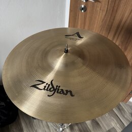 Zlatý kovový činel umístěný na stojanu. Na povrchu je černý nápis Zildjian a v horní části logo A s textem MEDIUM CRASH 18" / 45 cm. Povrch vykazuje…