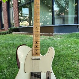 Elektrická kytara typu Telecaster v krémové barvě s javorovým hnedým hmatníkem. Tělo vykazuje známky opotřebení v podobě odřeni a škrábanců, zejména…