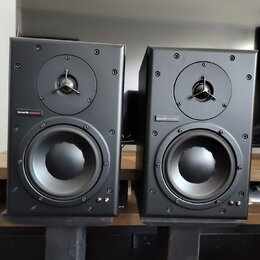 Dva černé studiové monitory v hranatých skříních. Na obou je umístěn nápis dynaudio acoustics. Každý reproduktor má v horní části výšek s kovovou mří…