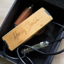 Dřevěný kytarový pedál s nápisy „Harley Benton“, „Volume“ a „Mic“. Pedál je umístěn v černé krabici s pěnovou výplní spolu s černým kabelem a kovovým…