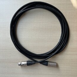 Černý mikrofonní kabel svinitý do kruhu. Na kabelu je bílý nápis PROFESSIONAL MICROPHONE CABLE — BY KLOTZ AUS GERMANY. Kabel má na koncích stříbrné k…
