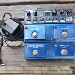 Modrý kytarový looper s kovovým povrchem a ovládacími prvky. Na horním panelu jsou nápisy JamMan, LOOP LEVEL, RHYTHM LEVEL, RECORD, PLAY, OVERDUB, MI…