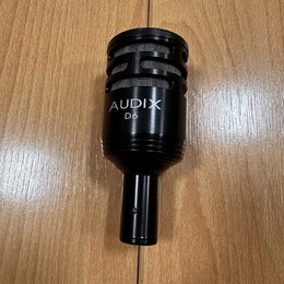Černý dynamický mikrofon s mřížkou v horní části. Na těle je bílý nápis AUDIX a pod ním model D6. Povrch mikrofonu je v dobrém stavu bez viditelného…