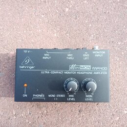 Černý kompaktní sluchátkový zesilovač s nápisy behringer a MicroMON MA400. Na předním panelu je text ULTRA-COMPACT MONITOR HEADPHONE AMPLIFIER, kontr…