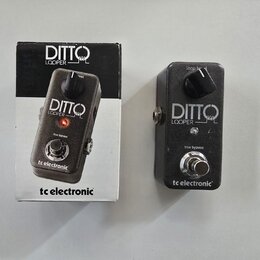 Na fotografii je kytarový pedál Ditto Looper v černé barvě s kovovým povrchem a jeho originální krabička. Na pedálu i na krabici je bílý nápis DITTO…