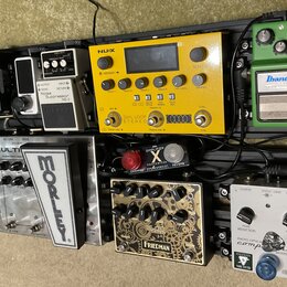 Sestava efektů na černém pedalboardu. Horní řada obsahuje pedály s nápisy SIMPLIFIER X, BOSS Noise Suppressor NS-2, žlutý procesor NUX s nápisem DUAL…