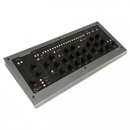 Šedý kontrolér s černým horním panelem a mnoha ovládacími knoflíky. V levém horním rohu je logo Softube a v pravém dolním rohu nápis CONSOLE 1. Panel…