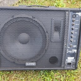 Černý kombozesilovač s kovovou ochrannou mřížkou přes celý přední panel. V dolní části mřížky je bílý nápis Laney. Na pravém boku se nachází ovládací…