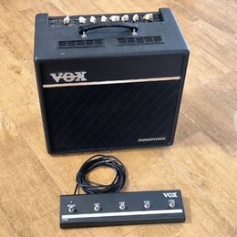 Černý kytarový kombozesilovač s nápisem VOX a označením Valvetronix. Na horní hraně jsou ovládací knoflíky a úchytka, přední stranu tvoří černá tkani…